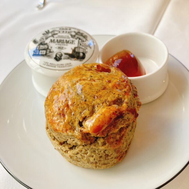 銀座松屋通り店限定の紅茶のスコーン。2025年夏のフレーバーは紅茶”ボレロ”を使用している。茶葉がふんだんに使用され、大きなドライアプリコットも生地からのぞいている。