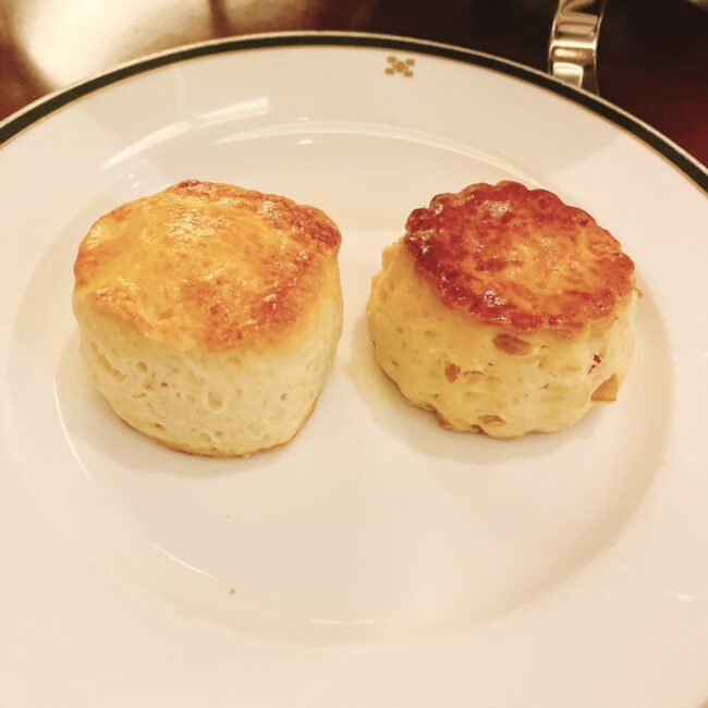 白い皿に、円形でこんがりと焼き色がつけられたスコーンが2つ並んでいる。左がレモンスコーン、右がプレーンスコーン。