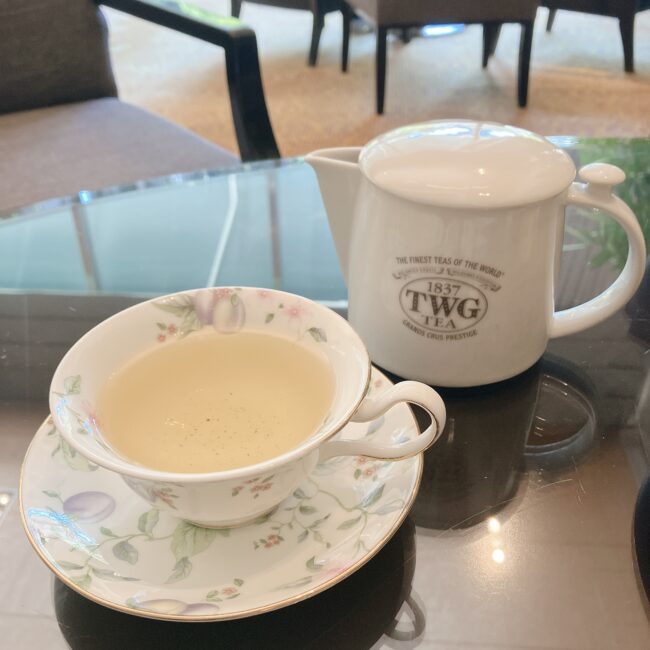 シェラトン都ホテル東京のアフタヌーンティー。手前にはTWG Teaのティーポットがあり、スコーンとスペシャルスイーツ、ガラスプレートのセイボリーが並んでいる。	