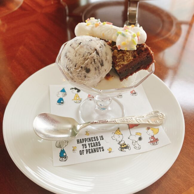 帝国ホテルのスヌーピーアフタヌーンティーのスペシャルスイーツ「チョコレートブラウニーサンデー」。チョコチップアイス、ブラウニー、骨型のメレンゲがグラスに入っている。