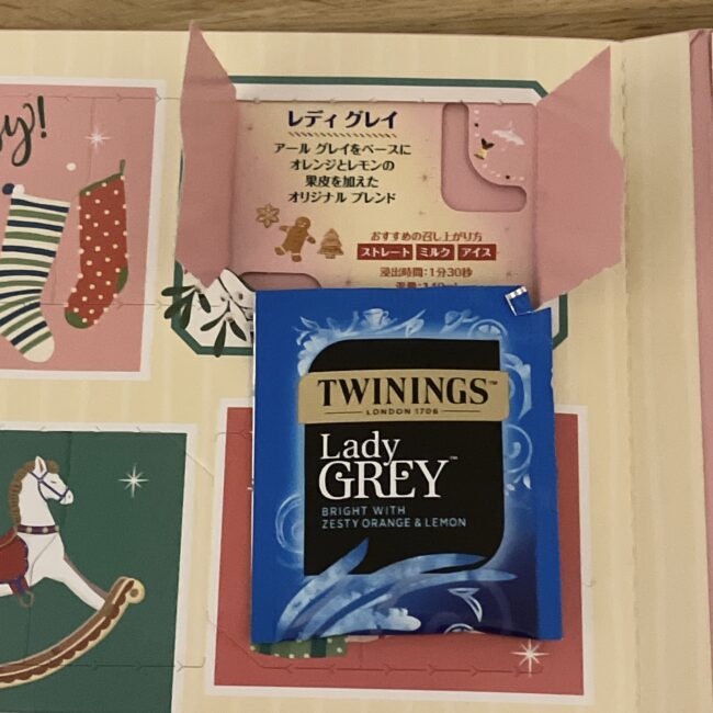 トワイニング アドヴェントカレンダー 2025、12月1日の窓を開けた写真。レディグレイのティーバッグと、窓の裏に記載されたフレーバー説明（柑橘系ブレンド）と淹れ方。