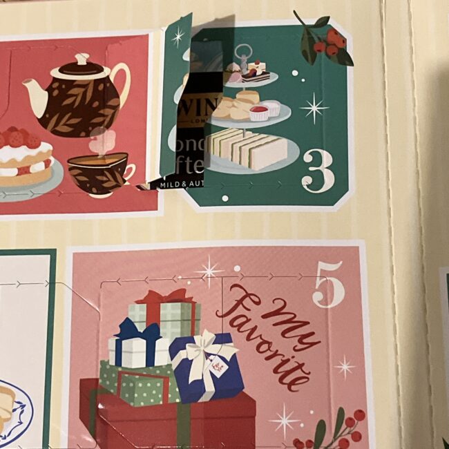 トワイニング アドヴェントカレンダー2025、3日目の開封写真。扉の裏から見える新商品「ロンドン アフタヌーン」のパッケージ。扉には三段トレーのアフタヌーンティーのイラスト。