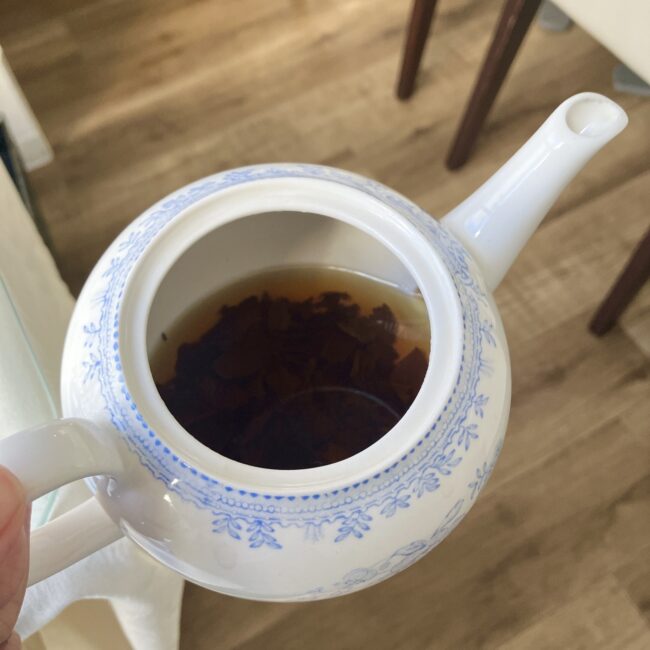 ジュリスティールームのティーポットの上からの写真。ポットの中には、たっぷりウヴァの茶葉が浮いている。