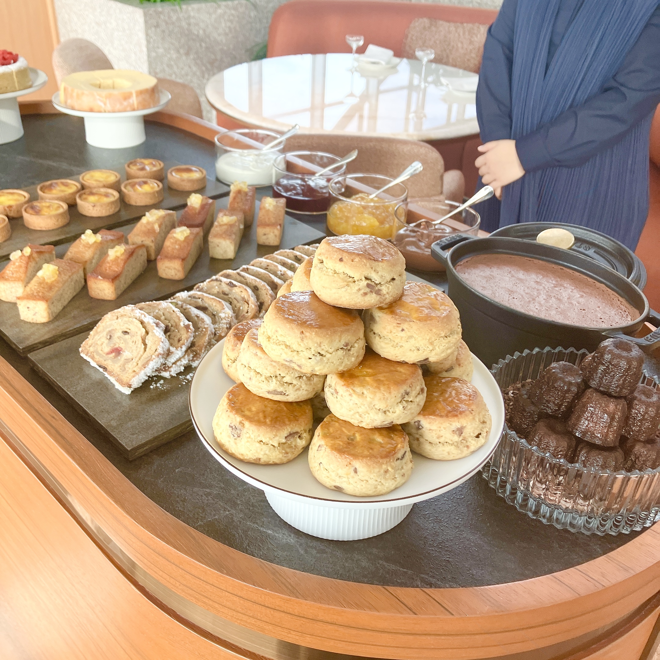 パークハイアット東京「ピークラウンジ」アフタヌーンティーの新サービス「トローリー」。手前には山積みにされた自家製スコーン、右にはカヌレ、奥にはフィナンシェやシュトレン、ポットに入った濃厚チョコムースなどが並ぶ食べ放題のワゴン"