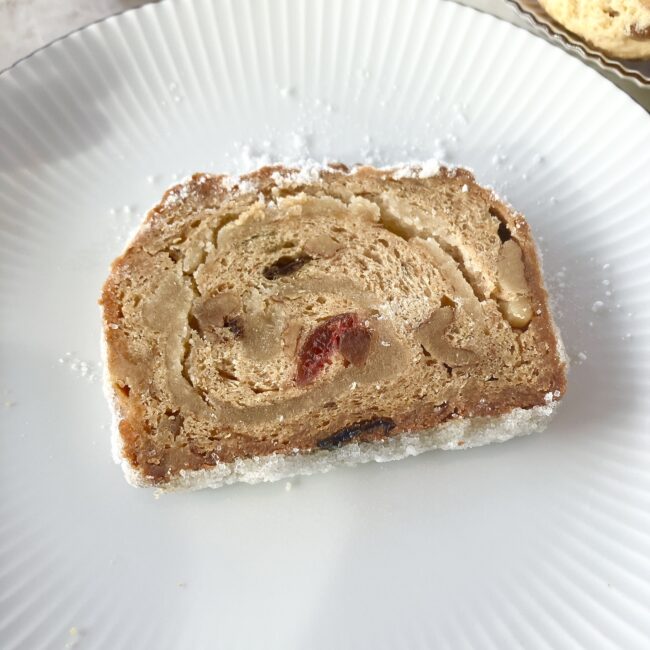 パークハイアット東京の「クリスマス・シュトレン」の断面。丁寧にロール状に巻かれた「渦巻き型」のマジパンと、大粒の赤いドライチェリー、ナッツが生地の中にぎっしりと詰まっている様子。