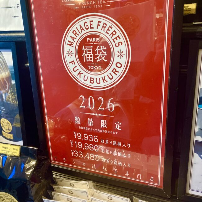 マリアージュフレール店頭に掲示された2026年福袋（FUKUBUKURO）の赤いポスター。9,936円、19,980円、33,480円の3種類の価格設定が記載されている。