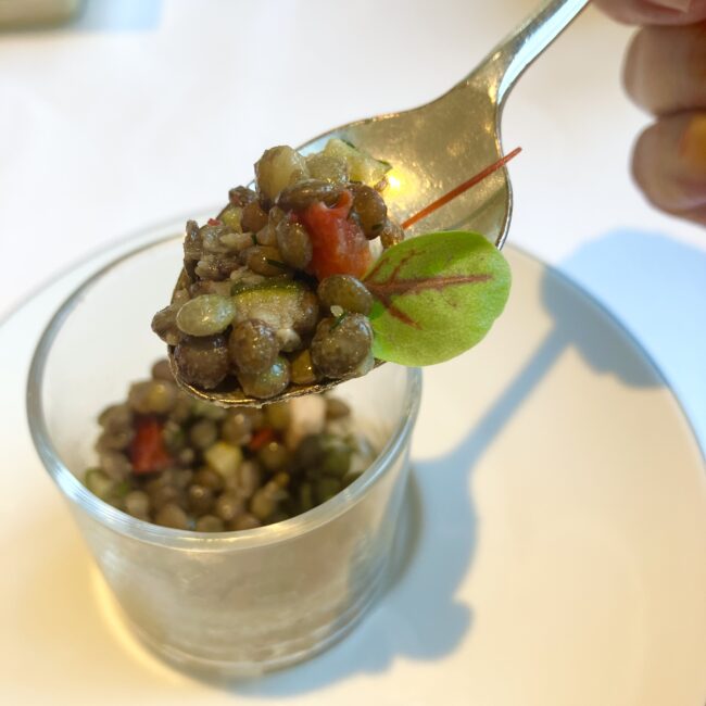 マリアージュフレールの前菜。お茶を使ったレンズ豆の料理をスプーンで掬ったクローズアップ。