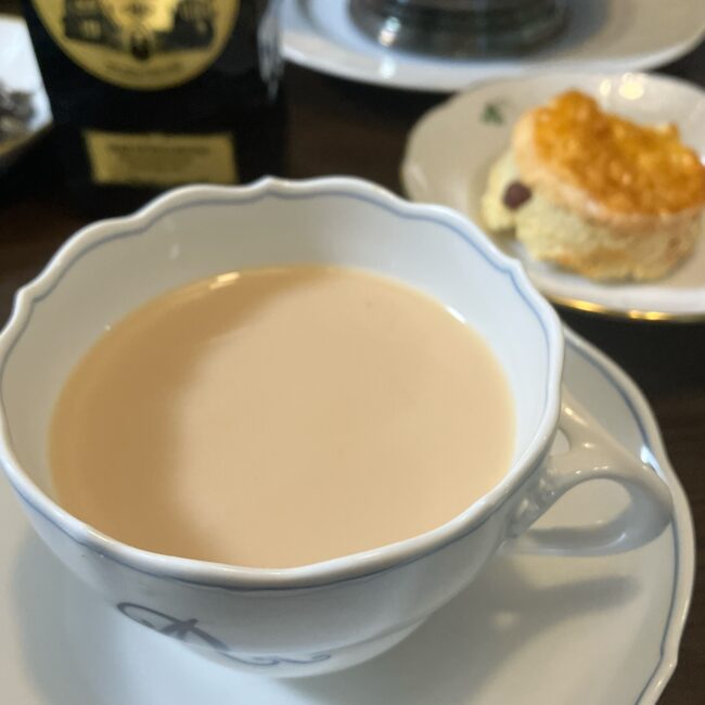 「ミルクを加え、絹のような質感になったデューク オブ ウェリントンのミルクティー。スコーンとのペアリングを楽しむ様子。」