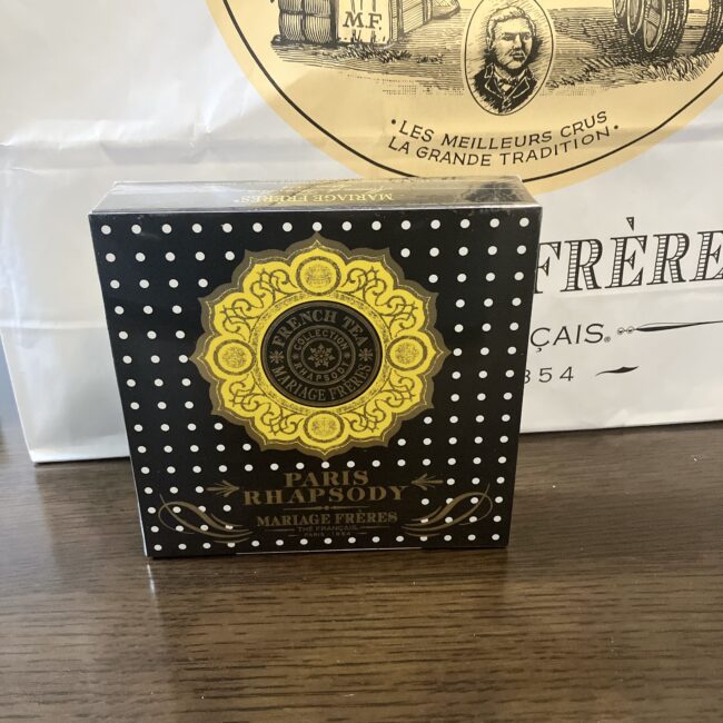 マリアージュフレールの「パリ ラプソディ」の正方形の外箱。黒地に白いドット模様と中央に黄色のエンブレム。