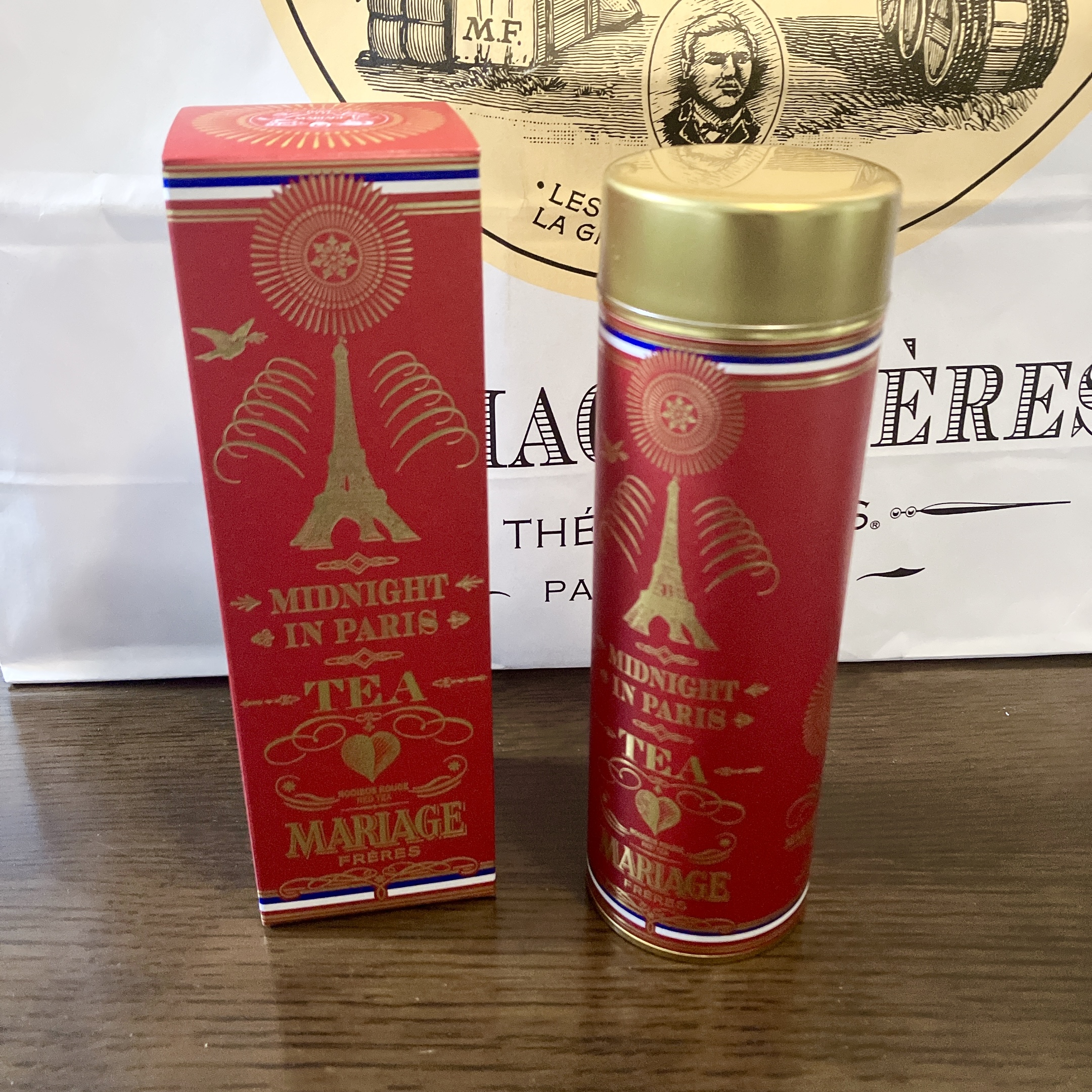 マリアージュフレールの「ミッドナイト イン パリ」の装丁缶と外箱。赤地にゴールドのエッフェル塔が描かれている。