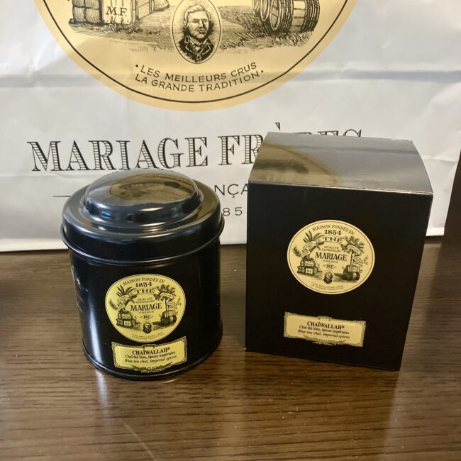 マリアージュフレールの「チャイワラ」の黒い丸缶と外箱。ラベルには「CHAIWALLAH」と記載されている。
