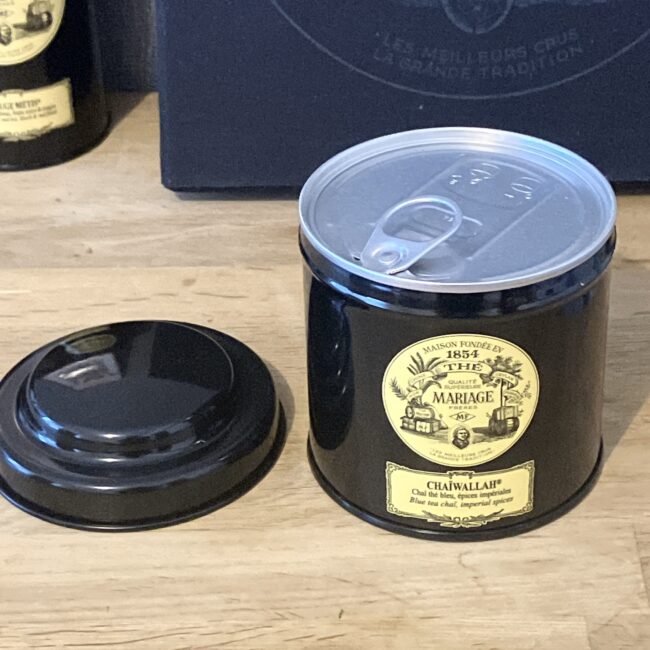 マリアージュフレールの紅茶缶「チャイワラ (CHAIWALLAH)」の開封前の状態。黒いクラシック缶の蓋が外され、その下に未開封のアルミ製プルタブの内蓋が見える。