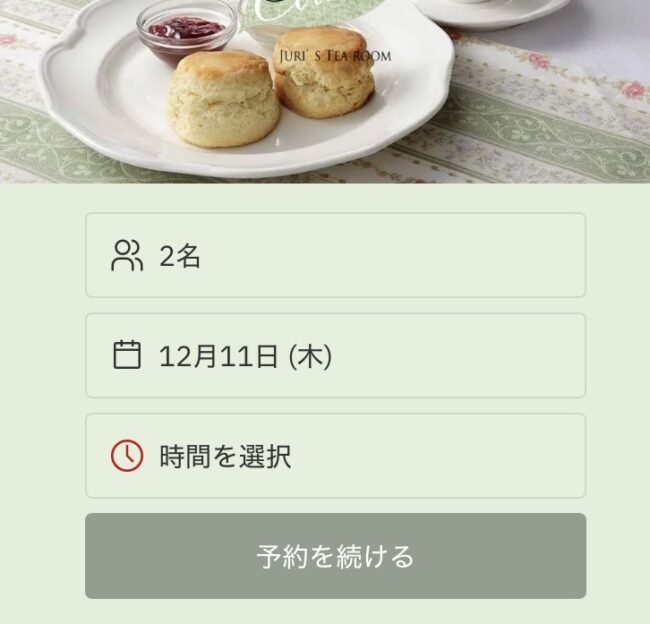 ジュリスティールームのウェブ予約画面。スコーンの写真と共に「2名」、「12月11日」が表示されている予約カレンダーの画面。