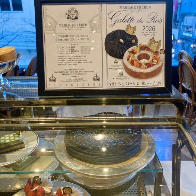 マリアージュフレール銀座松屋通り店のショーケースに陳列された2026年の黒いガレット・デ・ロアとポスター。