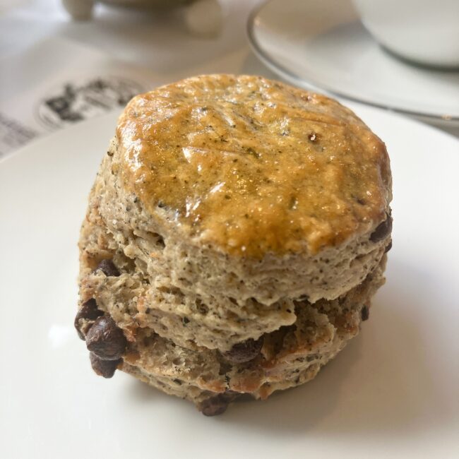 銀座松屋通り店限定のチョコレートスコーン。生地には「愛の讃歌 紅茶 ‘ウエディング インペリアル’」が練り込まれ、側面からたっぷりのチョコレートチップが覗く。表面は焼き色がついており、中央には狼の口のような割れ目がある。