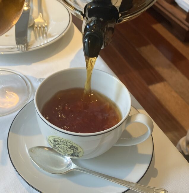 マリアージュフレールの「コロンビアン ブレックファースト チャイ (COLOMBIAN BREAKFAST CHAI) Ref. T5311」をカップに注いでいる瞬間。アール・デコのポットから注がれる紅茶は、カカオやスパイスが溶け込んだ温かみのある琥珀色をしている。