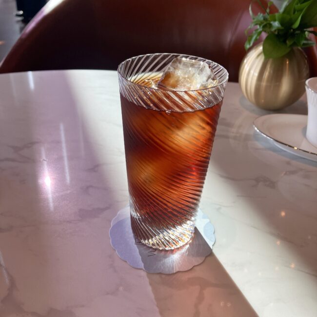 繊細なカッティングが施されたグラスに注がれた、アイスアールグレイティー。