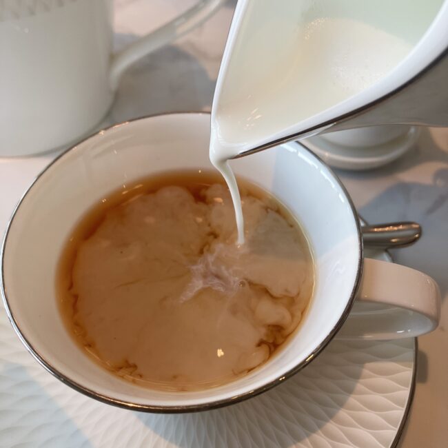 琥珀色の紅茶に、温められたミルクが注がれる様子。ミルクティーにして楽しむディンブラの豊かな味わい。