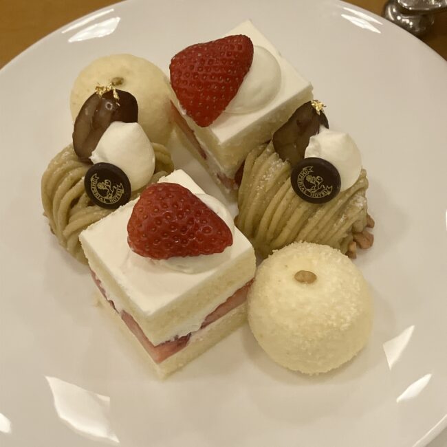 帝国ホテル ランデブーラウンジのアフタヌーンティースイーツ。苺のショートケーキ、和栗のモンブラン、丸い形のカマンベールチーズケーキが皿に盛られている。