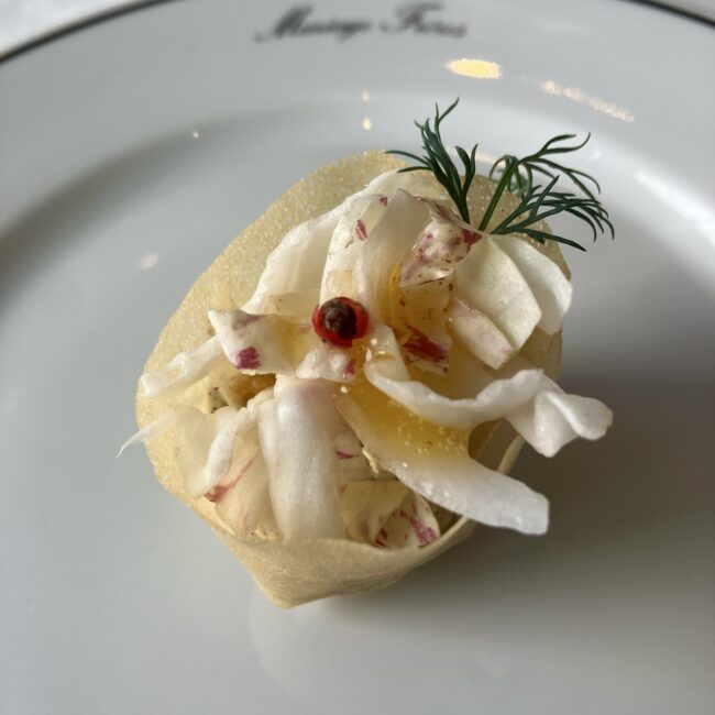 紅茶‘ボレロ’を使用した真鯛のムースリーヌ。クレープ生地の中に真鯛のムースが隠れており、オレンジソースとディルが添えられている。
