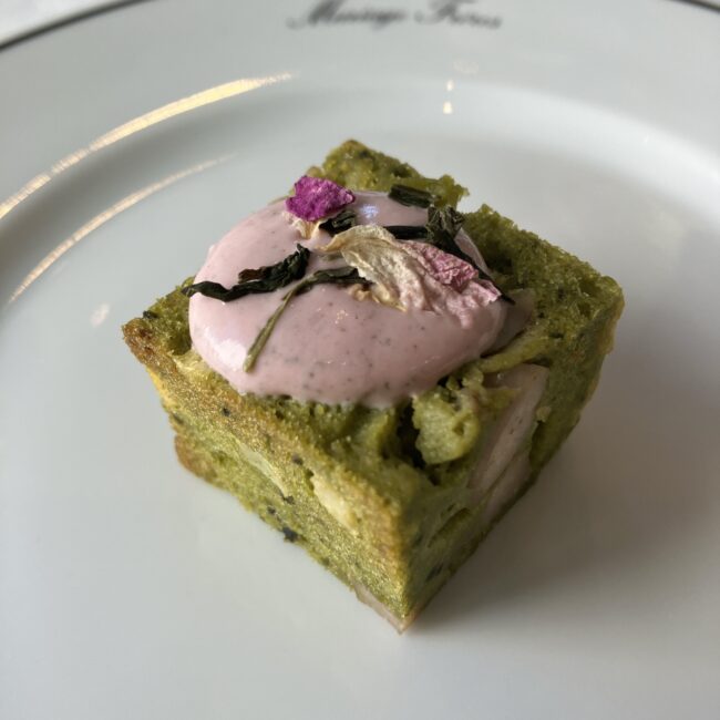 alt="マリアージュフレールのアフタヌーンティーで提供されたセイボリー。「リードヴォーと筍のケークサレ抹茶」。抹茶の緑色のケークサレの上に、ピンクのムースと桜の茶葉、花びらが乗った様子。"