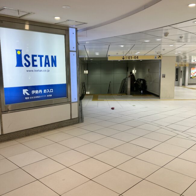 伊勢丹新宿店の入り口案内板と下り階段。英国展の開店前待機列の様子。