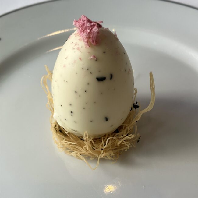 アフタヌーンティーのメインスイーツ『ニドワゾーオ テドパク 復活を祝う幸運の宴』。鳥の巣に乗った芸術的な白いイースターエッグ型のケーキ