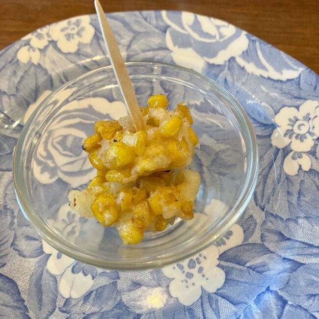 タイニートリアのイースターアフタヌーンティーのセイボリー。小さなガラスボウルに入ったサクサク食感の「スウィートコーンのフリット」。美しいブルーの花柄が描かれたバーレイのプレートに乗せられている。