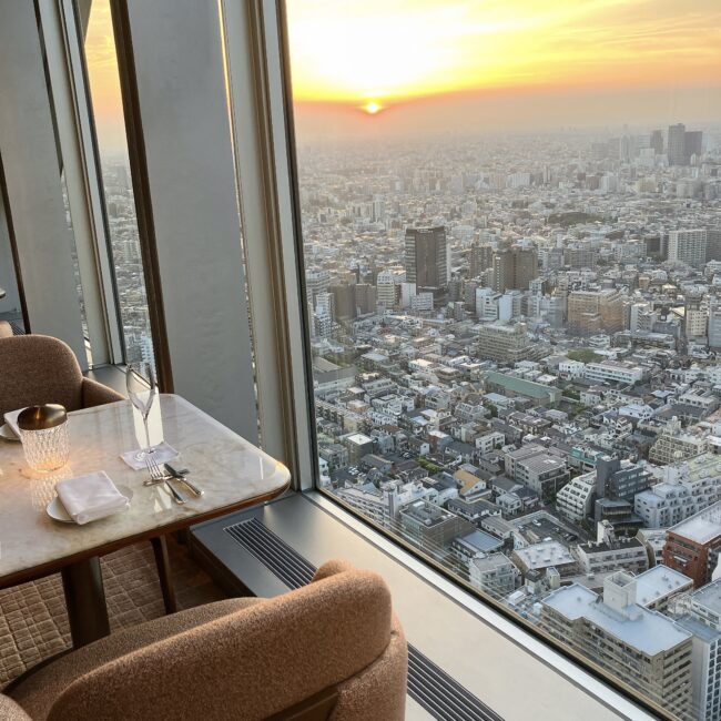 パークハイアット東京「ピーク ラウンジ」41階の窓際席から望む、美しい夕焼け(マジックアワー)と東京の街並み。