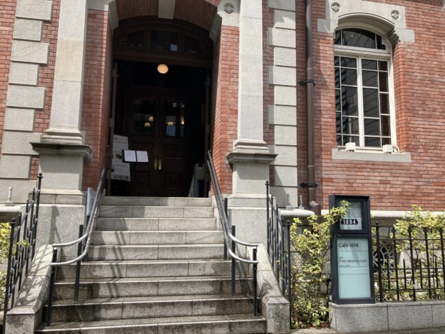 三菱一号館「Café 1894」のエントランス。趣のある石階段とクラシカルな木の扉。