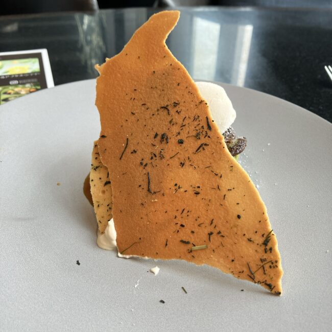 八女茶の茶葉が散りばめられた薄焼きの大きなクッキーのアップ