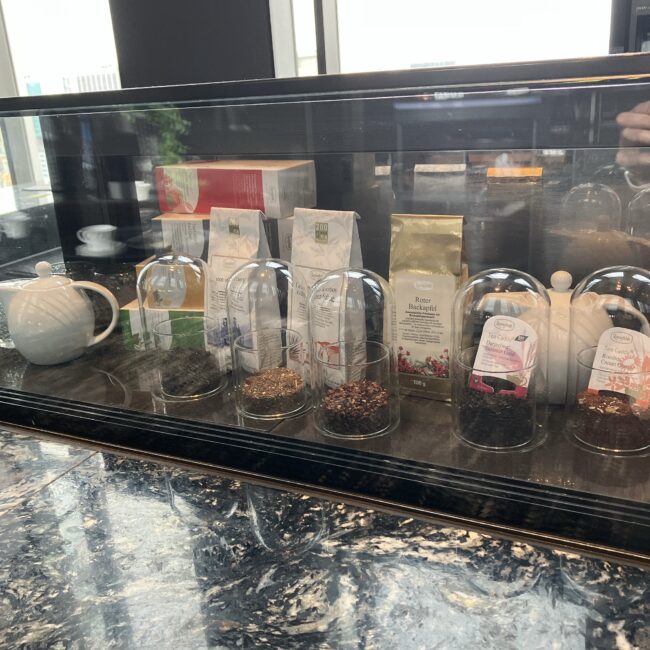ガラスケースの中に並べられた、様々な種類の乾燥茶葉の見本。黒大理石のカウンターに置かれている。