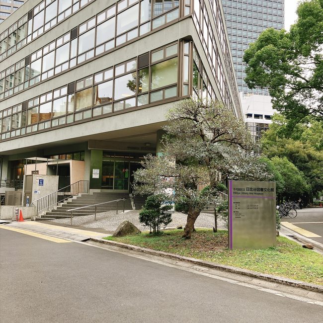 緑豊かな日比谷公園内に建つ、千代田区立日比谷図書文化館の外観と入り口の様子。