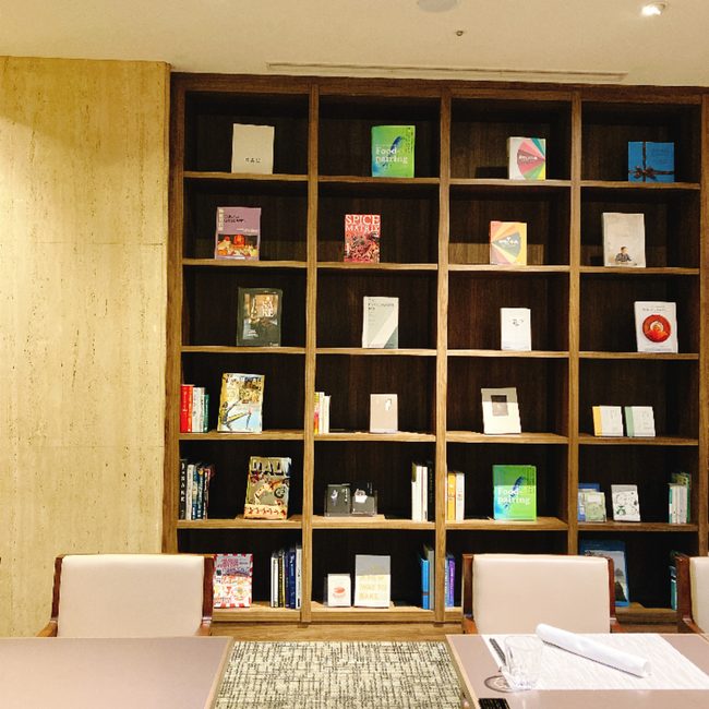 芝パークホテルのレストラン内の本棚。「Food Pairing」や「SPICE MATRIX」など、食に関する専門書やアート本がおしゃれにディスプレイされている。